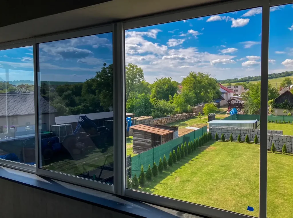 Panoramatické okno rodinného domu s tónovacou fóliou — pohľad z interiéru na okolie