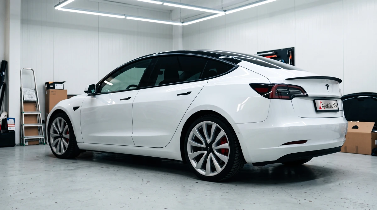 Biela Tesla Model 3 s tónovanými sklami v montážnej hale Armolan