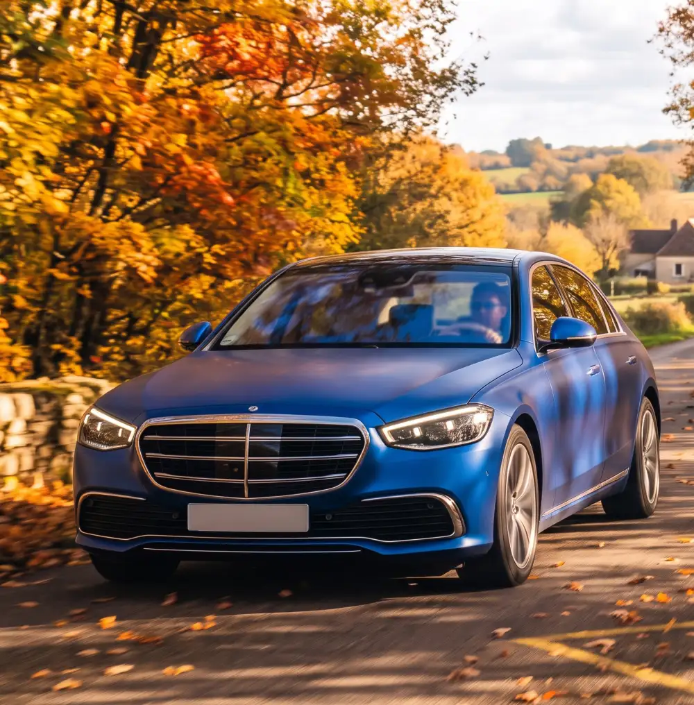 Modrý Mercedes triedy S s lesklým lakom chráneným fóliou PPF na jesennej ceste